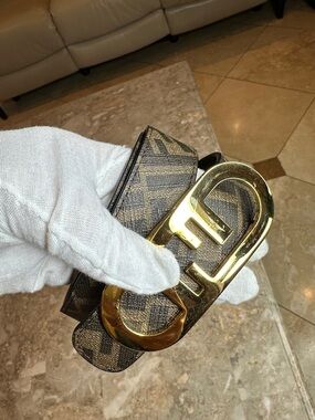 Fendi Brown Monogram Belt with Gold Logo Buckle Reversible with a black color.